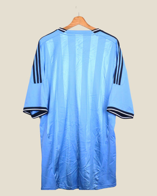 Kick Off Vintage Ajax 2011/12 away football shirt in light blue with navy Adidas stripes on a wooden hanger