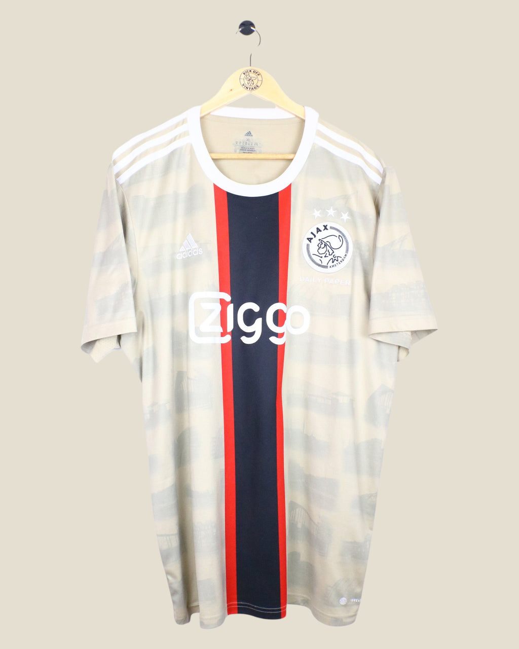 Kick Off Vintage Ajax 2022/23 third football jersey featuring Tadic, beige with a central red and black stripe.