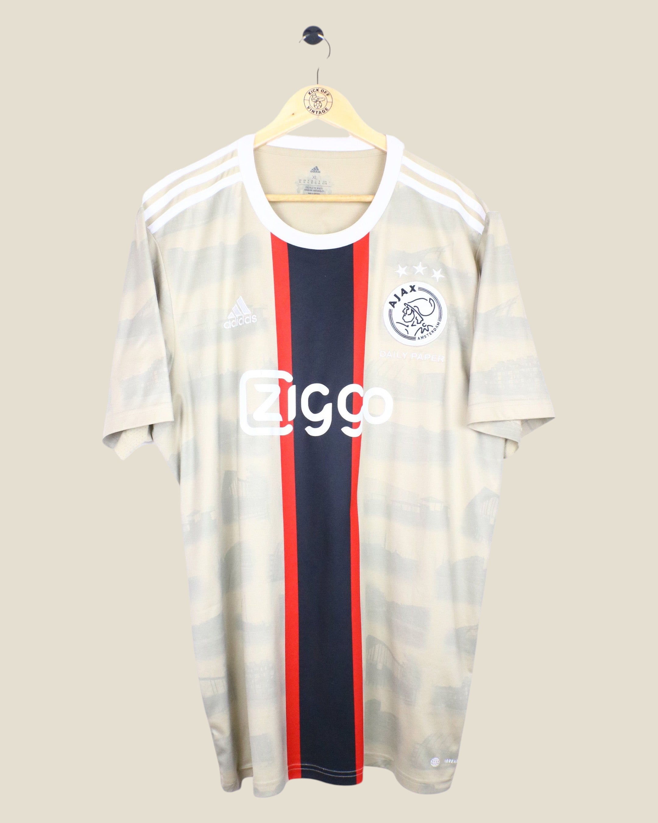 Kick Off Vintage Ajax 2022/23 third football jersey featuring Tadic, beige with a central red and black stripe.