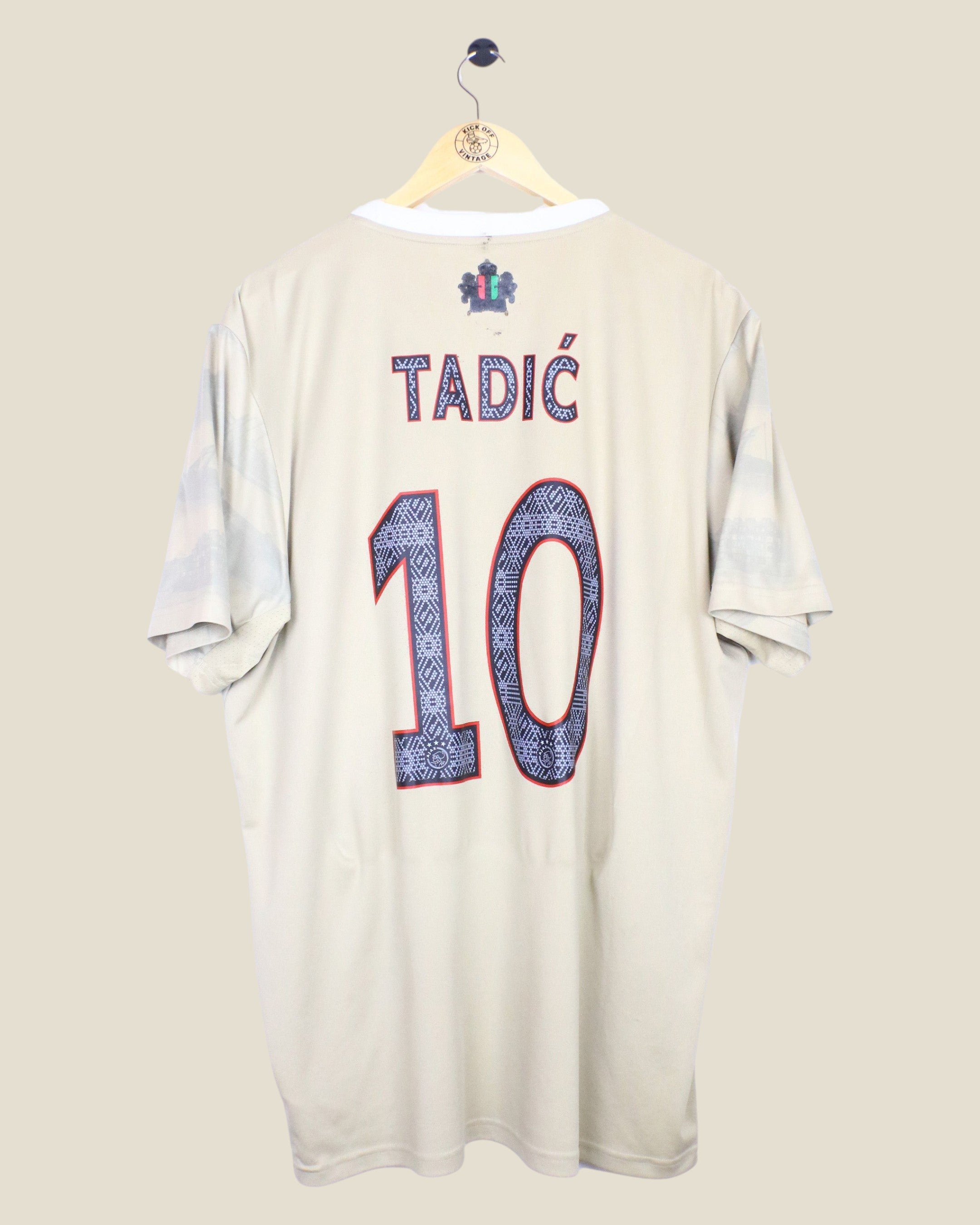 Kick Off Vintage Ajax 2022/23 third football shirt with Tadic 10 nameset on the back, beige jersey on a hanger.