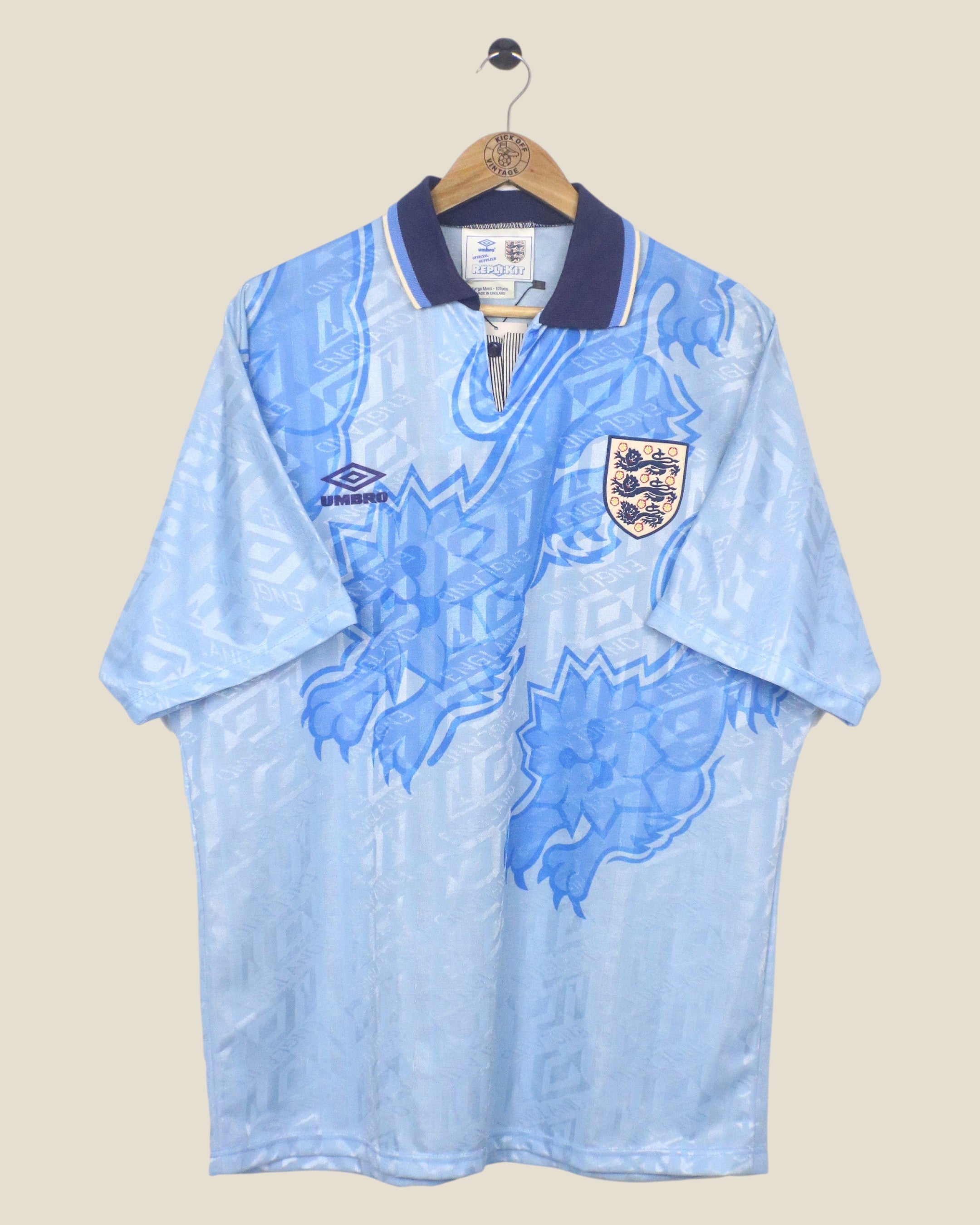 Kick Off Vintage 1992 England third football shirt in light blue with a navy collar and iconic lion graphic print.