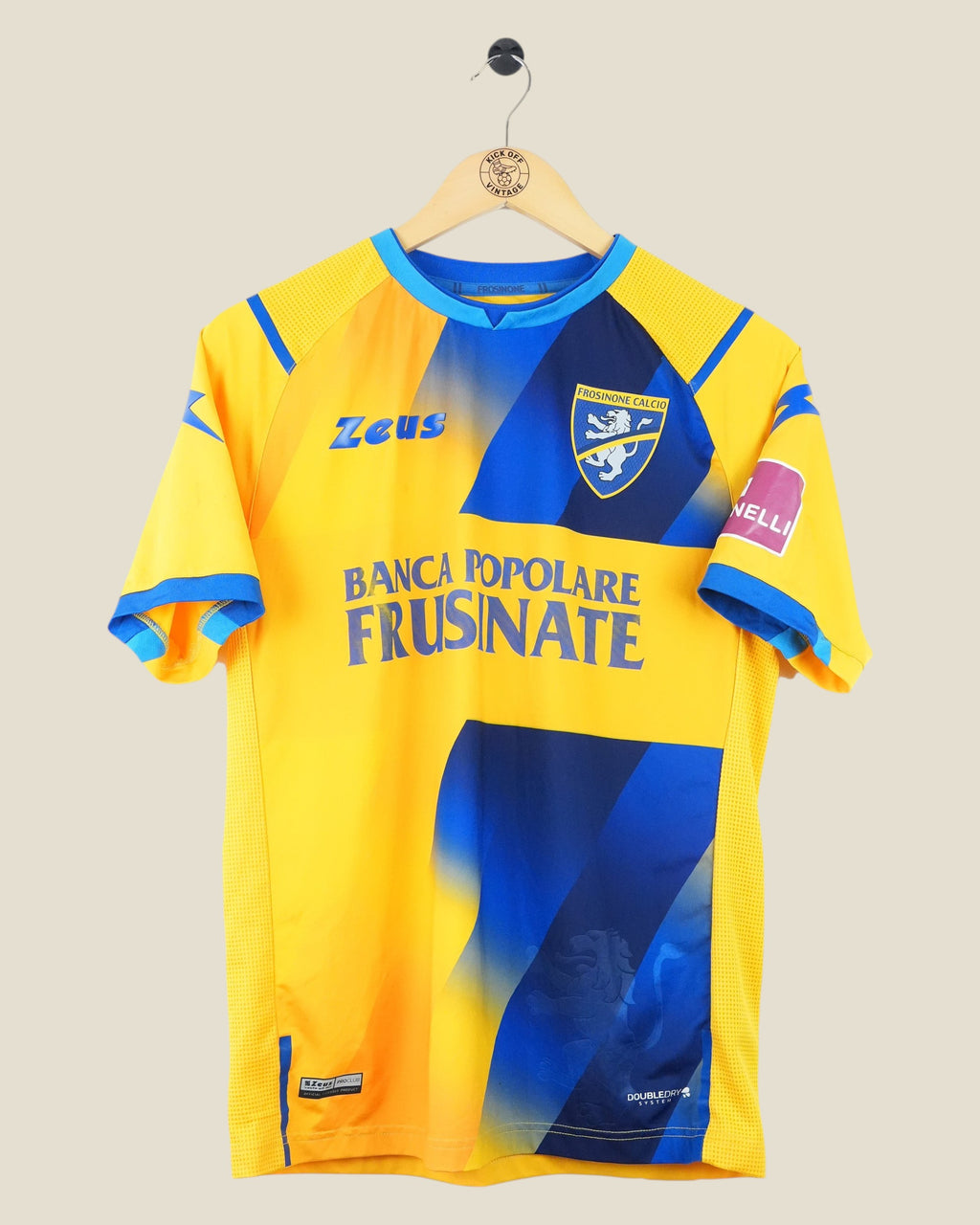 Kick Off Vintage Frosinone 2020/21 home football jersey in yellow and blue with Zeus branding on a wooden hanger.