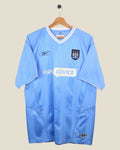 Kick Off Vintage Manchester City 2003/04 home football shirt in sky blue with white trim and Reebok branding.