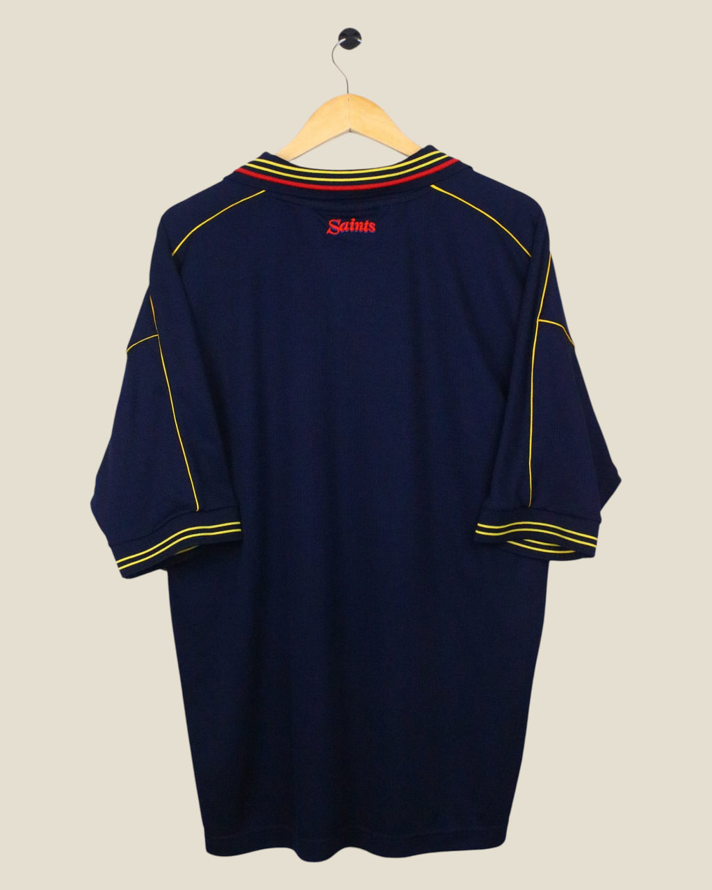 Kick Off Vintage Southampton 1999-01 away football shirt in navy blue with yellow and red trim on a wooden hanger